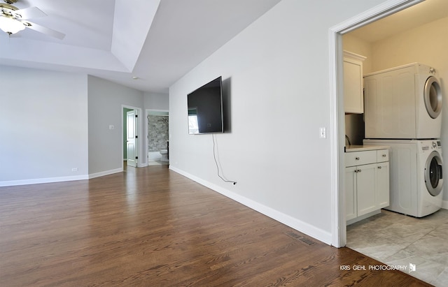 washroom featuring stacked washer and dryer, ceiling fan, and light hardwood / wood-style floors