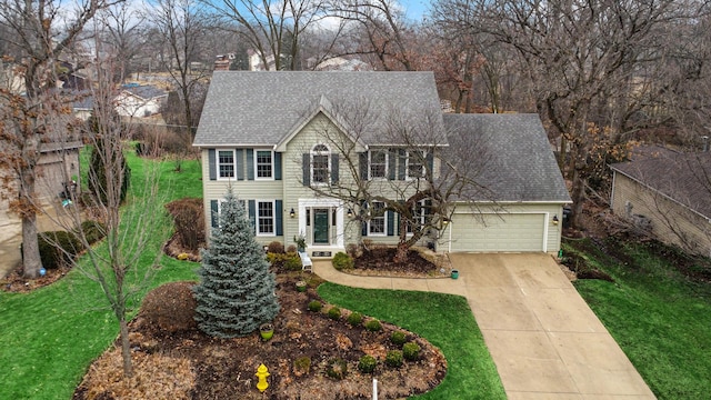 colonial-style house with a garage and a front lawn