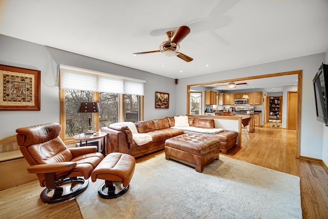 living room with ceiling fan and light hardwood / wood-style floors