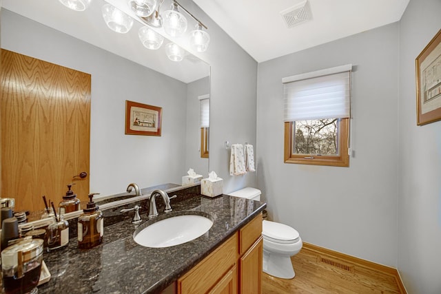 bathroom with vanity, hardwood / wood-style floors, and toilet