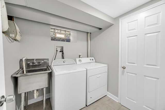 washroom with independent washer and dryer, light tile patterned floors, and sink