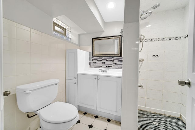 bathroom with toilet, vanity, decorative backsplash, and tile walls