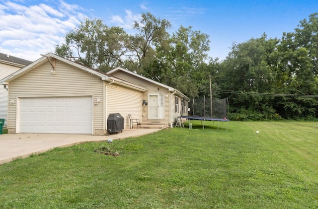 exterior space featuring a front yard, a garage, and a trampoline