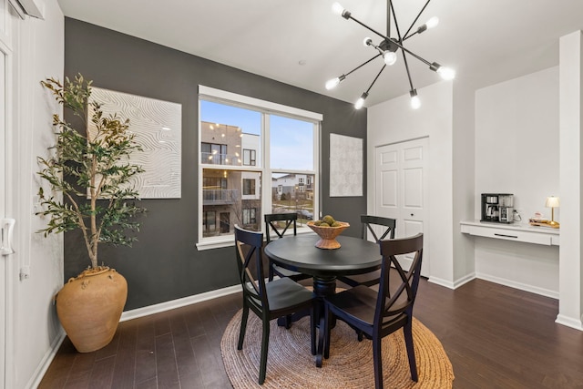 dining room with dark hardwood / wood-style flooring and a chandelier