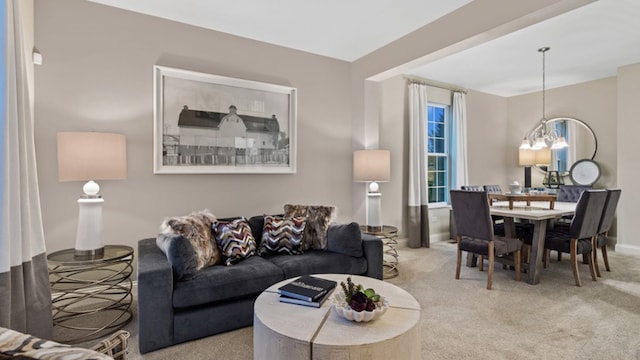 living room with a notable chandelier and light carpet