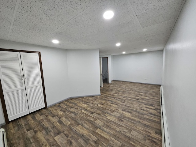 basement featuring dark wood-type flooring and a paneled ceiling