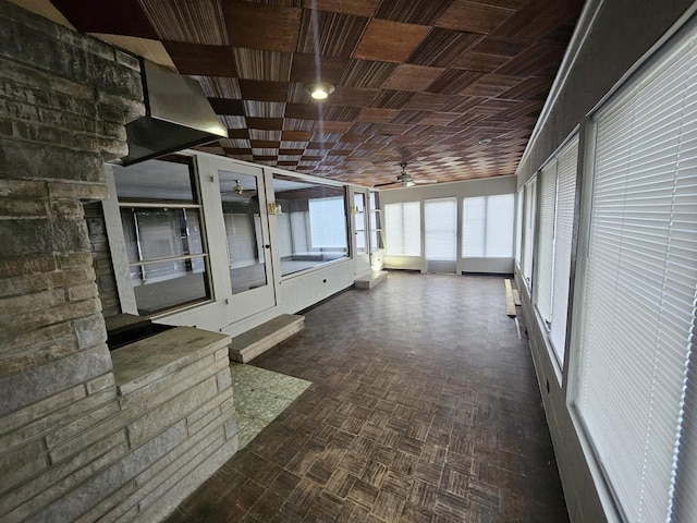 unfurnished sunroom featuring ceiling fan