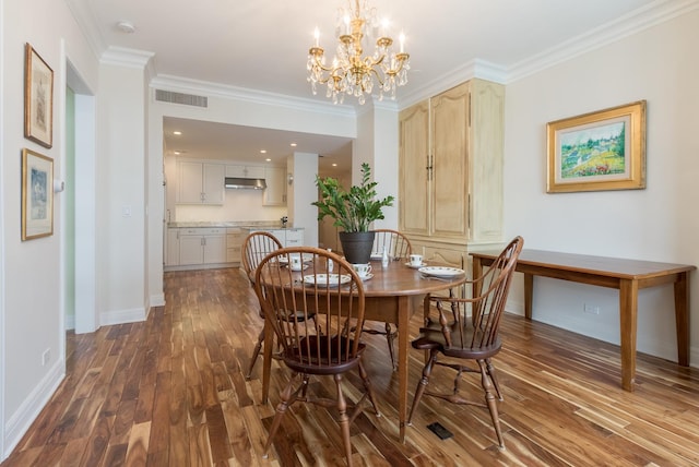 dining room featuring ornamental molding, an inviting chandelier, and hardwood / wood-style flooring