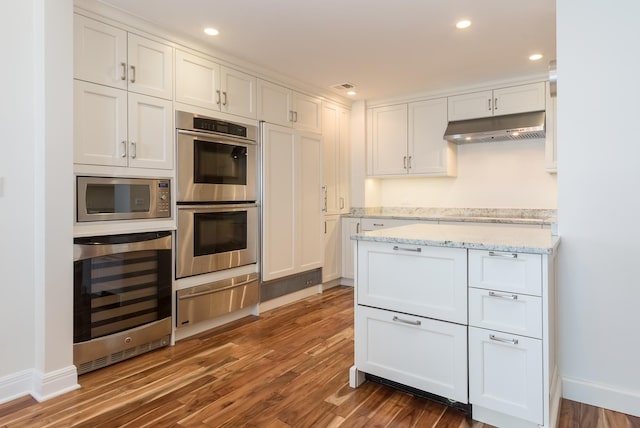 kitchen featuring stainless steel appliances, beverage cooler, white cabinetry, and dark hardwood / wood-style floors