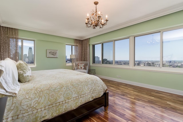 bedroom with a chandelier, ornamental molding, and hardwood / wood-style flooring