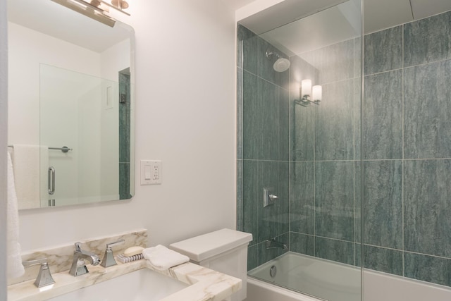 bathroom featuring combined bath / shower with glass door and vanity