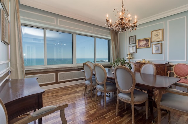 dining room featuring a chandelier, a wealth of natural light, and a water view