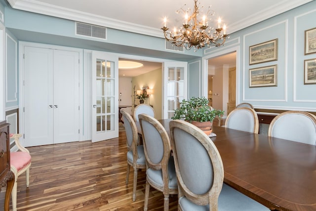 dining space featuring a notable chandelier, dark hardwood / wood-style flooring, french doors, and crown molding