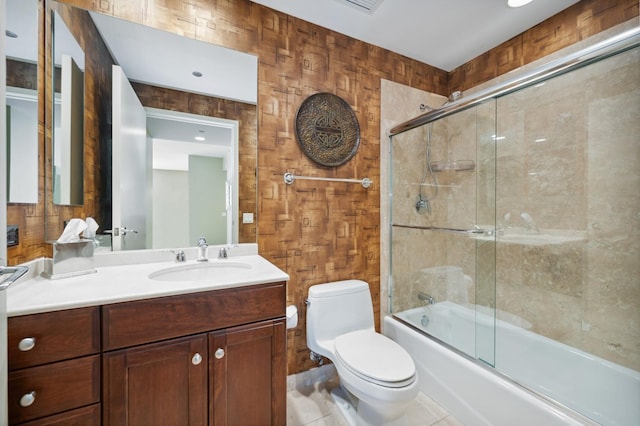 full bathroom with shower / bath combination with glass door, tile patterned flooring, toilet, wood walls, and vanity