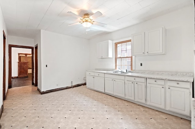 kitchen featuring sink, white cabinetry, and ceiling fan