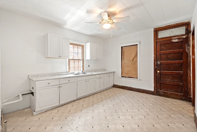 kitchen with sink, ceiling fan, and white cabinetry