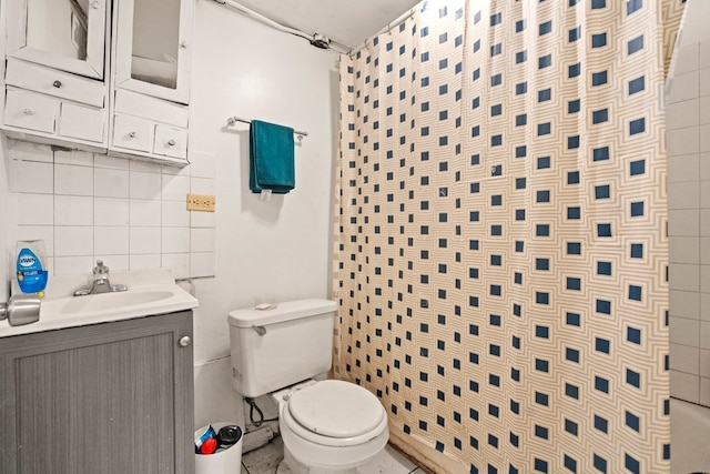 bathroom with toilet, vanity, and decorative backsplash