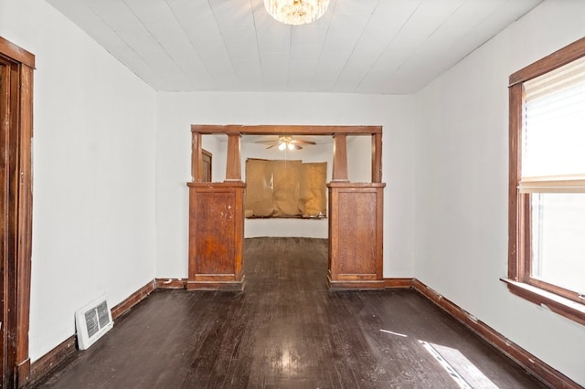 unfurnished room featuring ceiling fan, a healthy amount of sunlight, and dark wood-type flooring