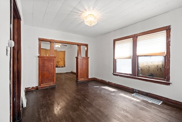 unfurnished room featuring dark wood-type flooring and ceiling fan with notable chandelier