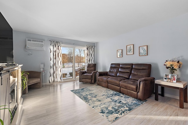 living room featuring light hardwood / wood-style floors and an AC wall unit