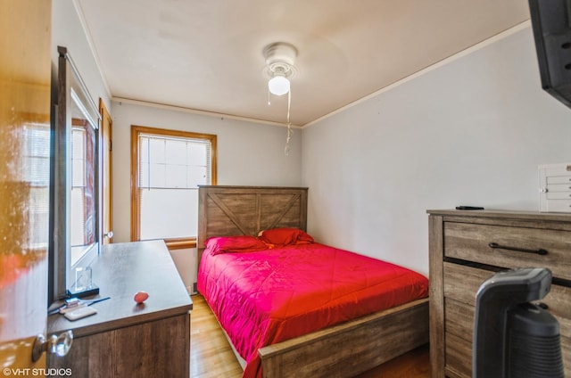 bedroom featuring light hardwood / wood-style floors, ceiling fan, and ornamental molding