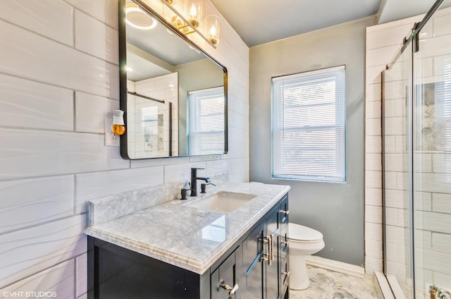 bathroom with a shower with door, backsplash, vanity, and toilet