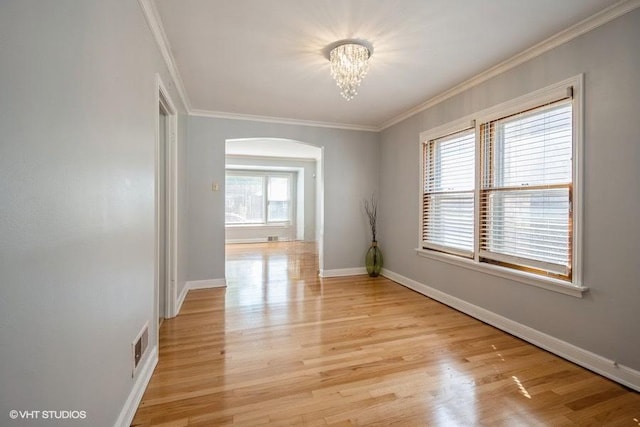 unfurnished room with crown molding, a notable chandelier, and light hardwood / wood-style flooring