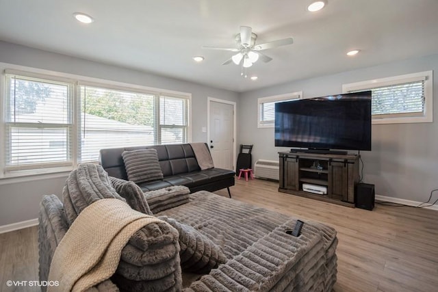 living room with ceiling fan, light wood-type flooring, and a wealth of natural light