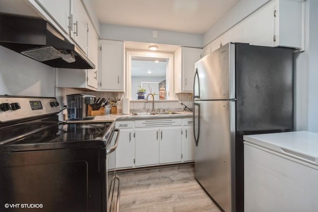 kitchen with appliances with stainless steel finishes, light wood-type flooring, white cabinets, and sink