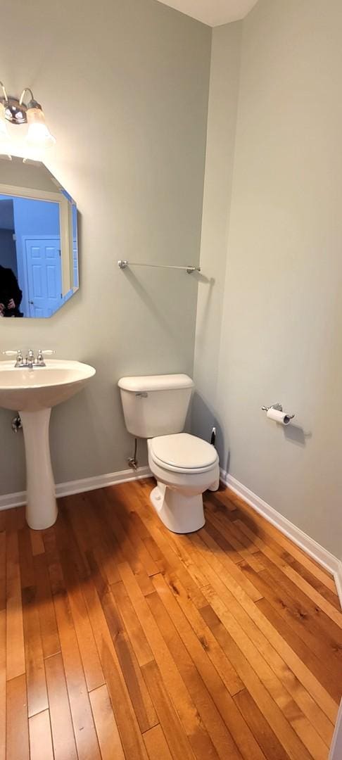 bathroom with toilet, sink, and hardwood / wood-style floors