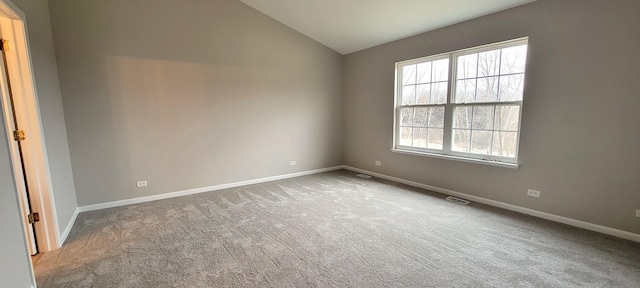 empty room featuring carpet floors and vaulted ceiling