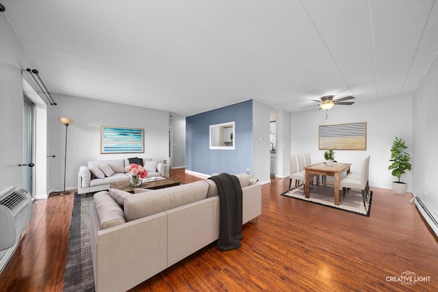 living room with dark wood-type flooring, ceiling fan, and baseboard heating