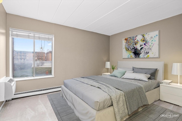 bedroom with carpet flooring and a baseboard heating unit