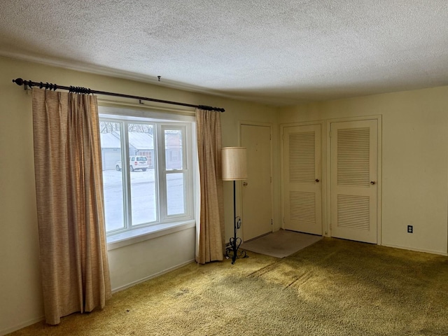 carpeted empty room featuring a textured ceiling and a healthy amount of sunlight