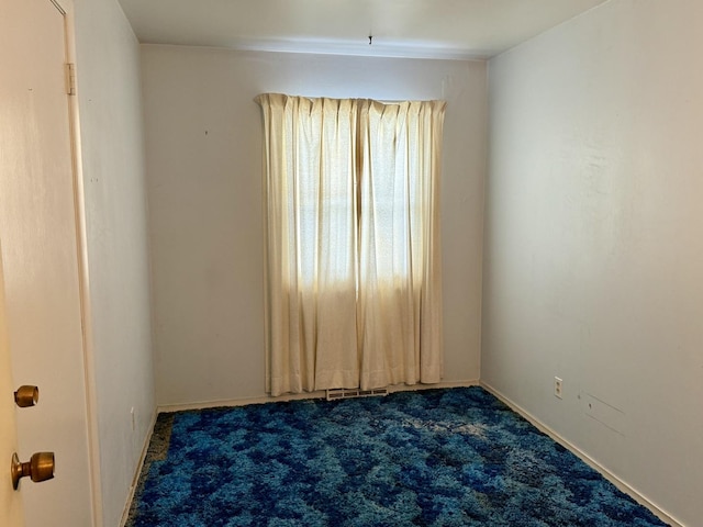 spare room with dark carpet