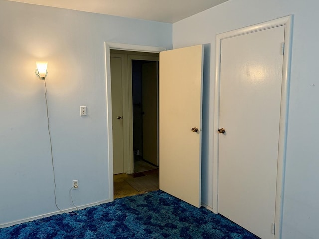 unfurnished bedroom with dark colored carpet