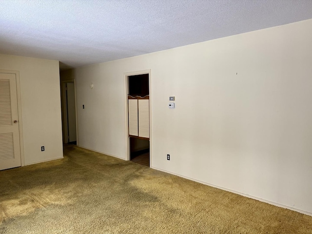 empty room with a textured ceiling and carpet flooring