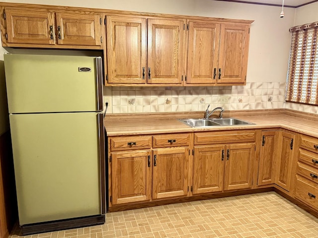 kitchen featuring sink, refrigerator, and tasteful backsplash