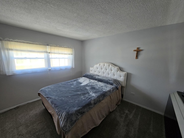 bedroom featuring a textured ceiling and dark colored carpet