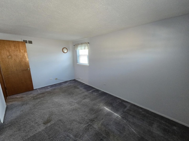 carpeted spare room featuring a textured ceiling