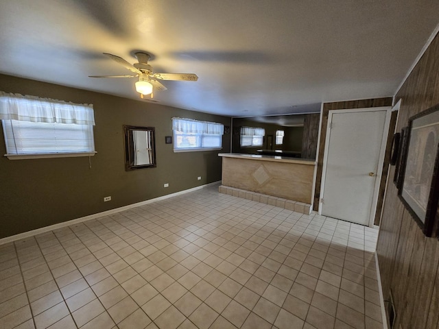 tiled spare room with wooden walls and ceiling fan