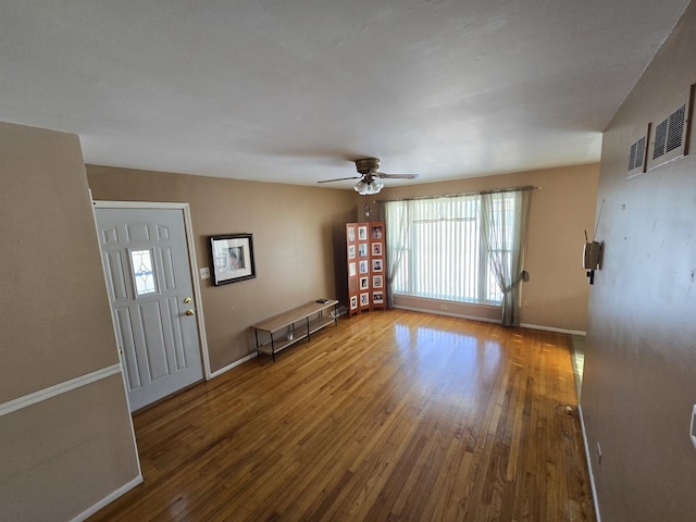 unfurnished living room with wood-type flooring and ceiling fan