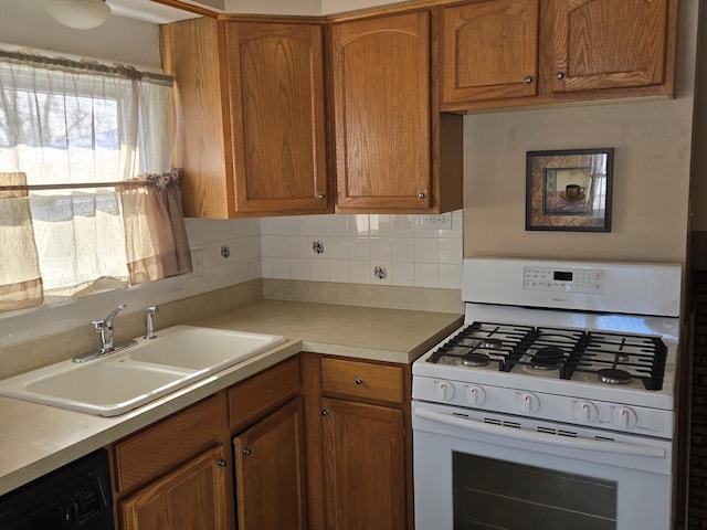 kitchen with sink, white gas range oven, tasteful backsplash, and dishwasher