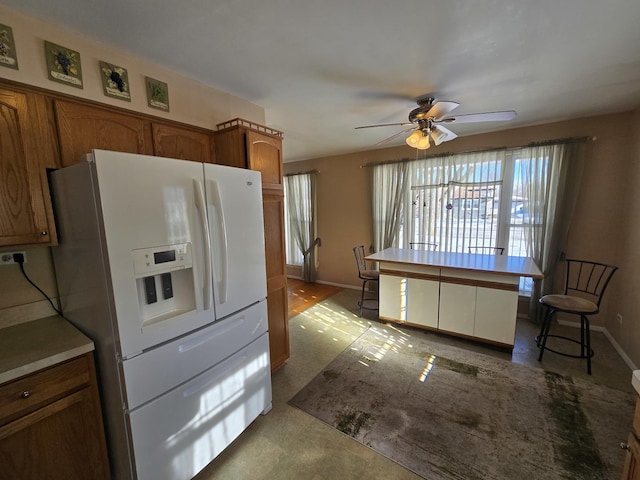 kitchen featuring ceiling fan and white fridge with ice dispenser