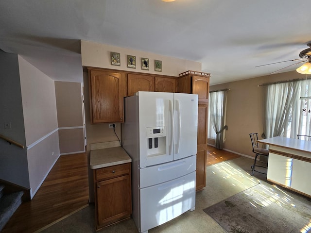 kitchen featuring white fridge with ice dispenser and ceiling fan