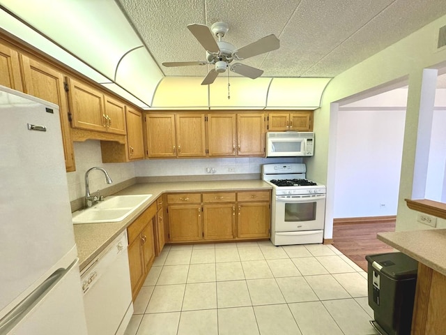 kitchen with sink, white appliances, ceiling fan, and light tile patterned floors