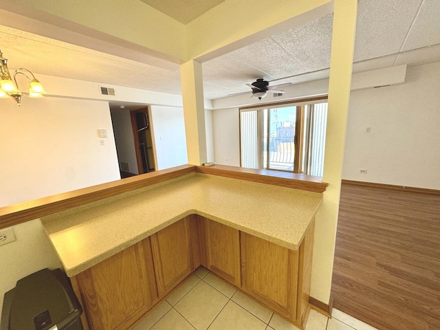 interior space with ceiling fan with notable chandelier and light tile patterned floors