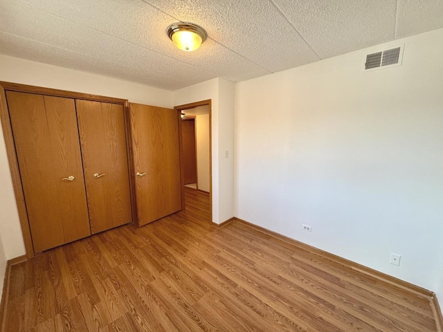 unfurnished bedroom featuring a closet and light wood-type flooring