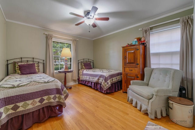 bedroom with ceiling fan, crown molding, and light hardwood / wood-style floors