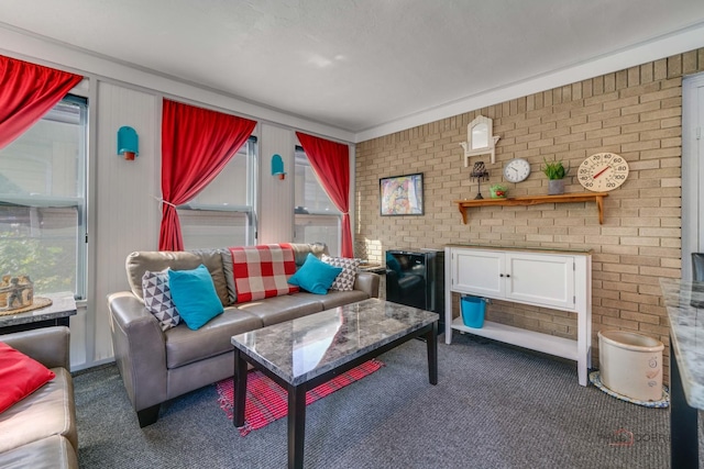 carpeted living room with plenty of natural light and brick wall